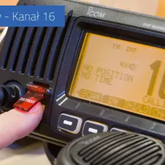 Palec naciska przycisk "DISTRESS" na radiu VHF, które wyświetla kanał 16.
