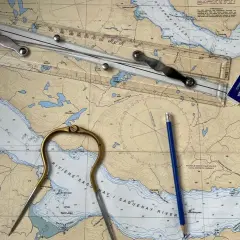 Nawigacja po rzece Saguenay: cyrkiel, ołówek i linijka na mapie. Planowana trasa ma długość 1 mila morska.