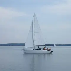 Biały jacht "Ramzesowa" płynie po spokojnym akwenie, przypominającym Marmara Morze. Na pokładzie widać kilka osób.