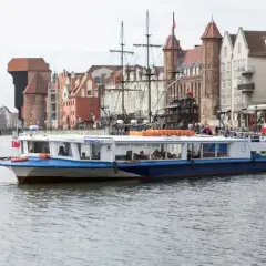 Statek wycieczkowy "Sonica 1" płynie po Motławie w Gdańsku. W tle widać zabytkowe kamienice i Żuraw. Doskonała nawigacja po wodach miasta.