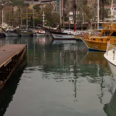 Drewniany pomost i zacumowane statki, w tym jeden z widocznym szpringiem dziobowym.