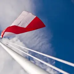 Biało-czerwona flaga powiewa na tle błękitnego nieba. Czy można wywiesić flagę innego kraju? To pytanie zadaje sobie wielu.