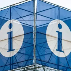 Niebieska konstrukcja z białymi okręgami i literą "i" symbolizuje system informacji.