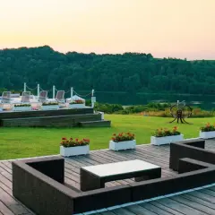 Idealne mazury na weekend: taras z meblami, basen z leżakami i jezioro w tle.