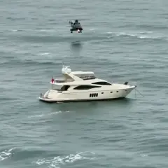 Luksusowy jacht motorowy na wzburzonym morzu, nad którym unosi się helikopter. Zastanawiasz się, ile pali jacht motorowy?