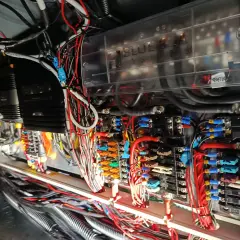 Skomplikowana instalacja elektryczna na jachcie, z widocznymi bezpiecznikami, przewodami i skrzynką "Blue Sea Systems".