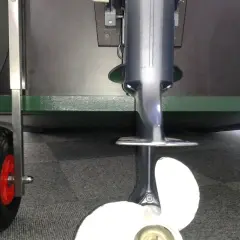Trymowanie silnika zaburtowego na wózku. Widoczny wał, śruba i koła.