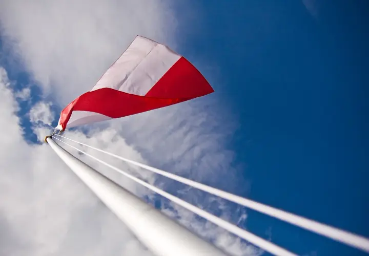 Biało-czerwona flaga powiewa na tle błękitnego nieba. Czy można wywiesić flagę innego kraju? To pytanie zadaje sobie wielu.