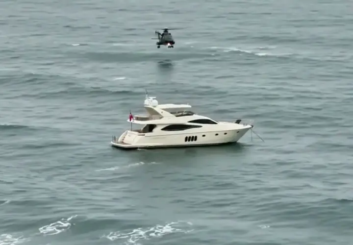 Luksusowy jacht motorowy na wzburzonym morzu, nad którym unosi się helikopter. Zastanawiasz się, ile pali jacht motorowy?