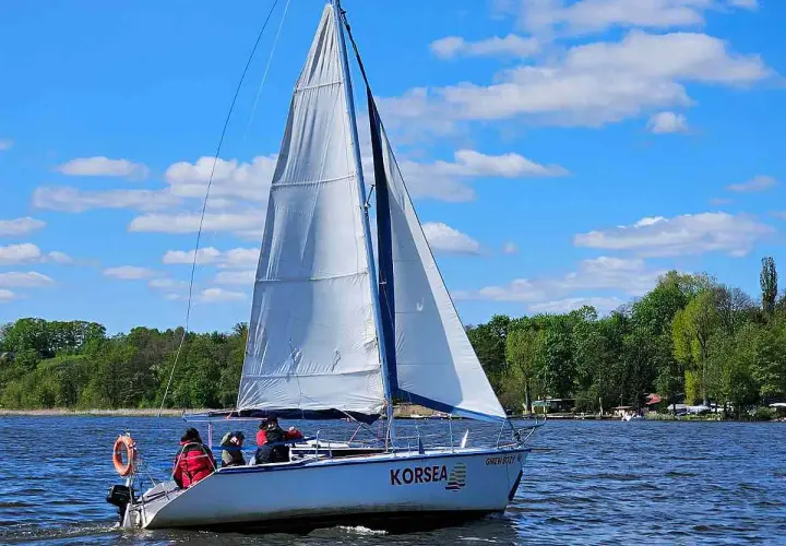 Żaglówka "KORSEA" płynie po jeziorze, osiągając dobrą morska jednostka prędkości.