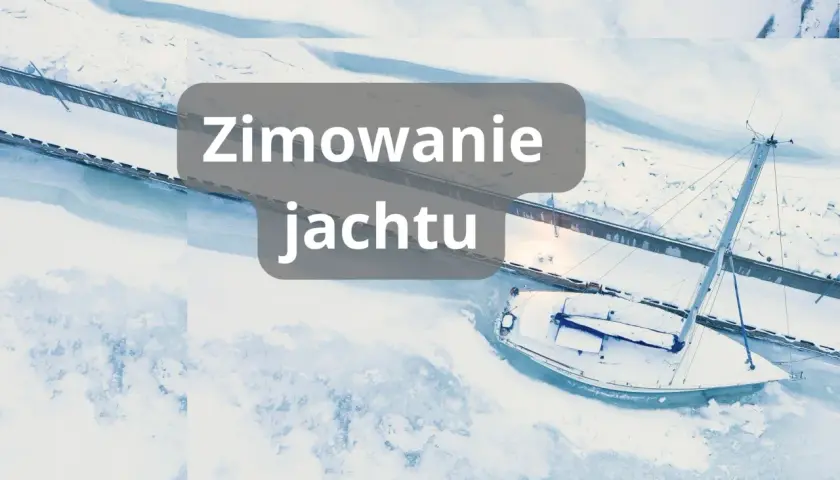 Zimowanie jachtu w zamarzniętej marinie. Biały żaglowiec pokryty śniegiem czeka na wiosnę.