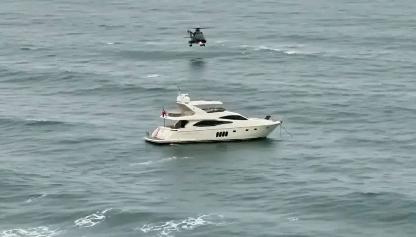 Luksusowy jacht motorowy na wzburzonym morzu, nad którym unosi się helikopter. Zastanawiasz się, ile pali jacht motorowy?
