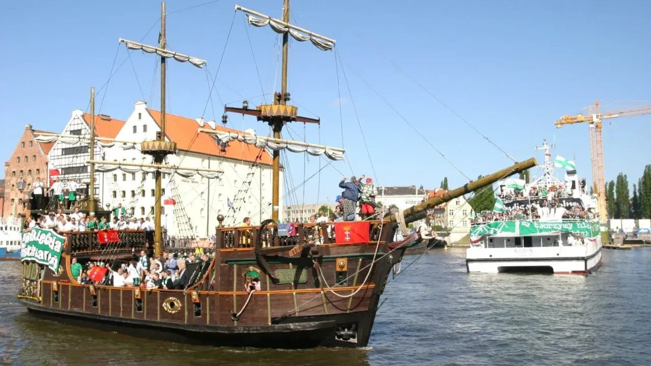 Gdańsk wycieczka statkiem pirackim i nowoczesną jednostką, pełne ludzi w zielonych barwach.