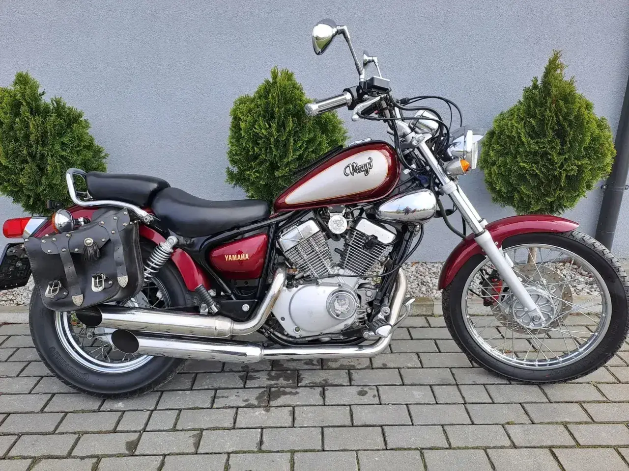 Czerwony motocykl Yamaha Virago z sakwami. Chcesz wiedzieć, jak sprawdzić rok produkcji silnika zaburtowego Yamaha? Ten model może być pomocny.