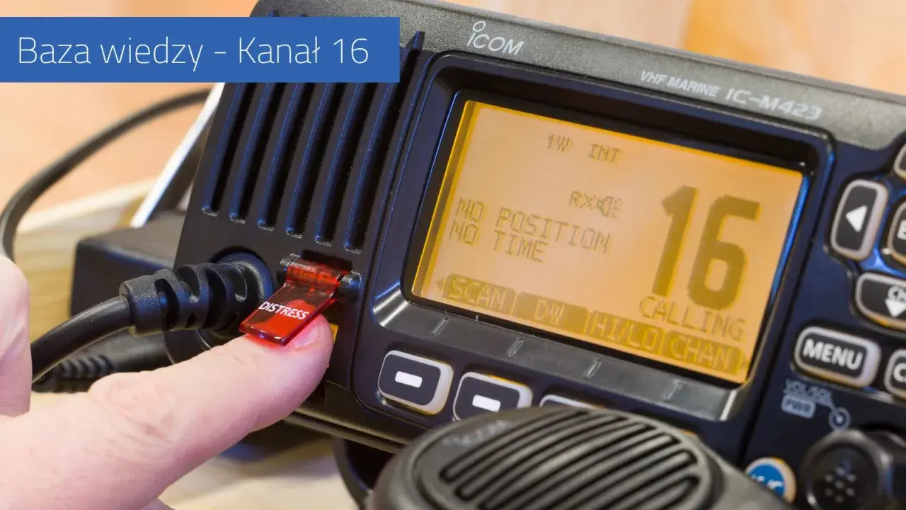 Palec naciska przycisk "DISTRESS" na radiu VHF, które wyświetla kanał 16.