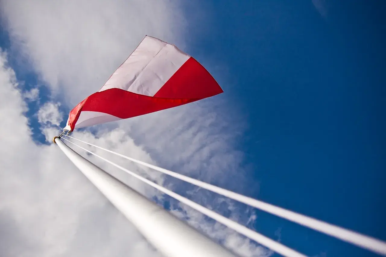 Biało-czerwona flaga powiewa na tle błękitnego nieba. Czy można wywiesić flagę innego kraju? To pytanie zadaje sobie wielu.