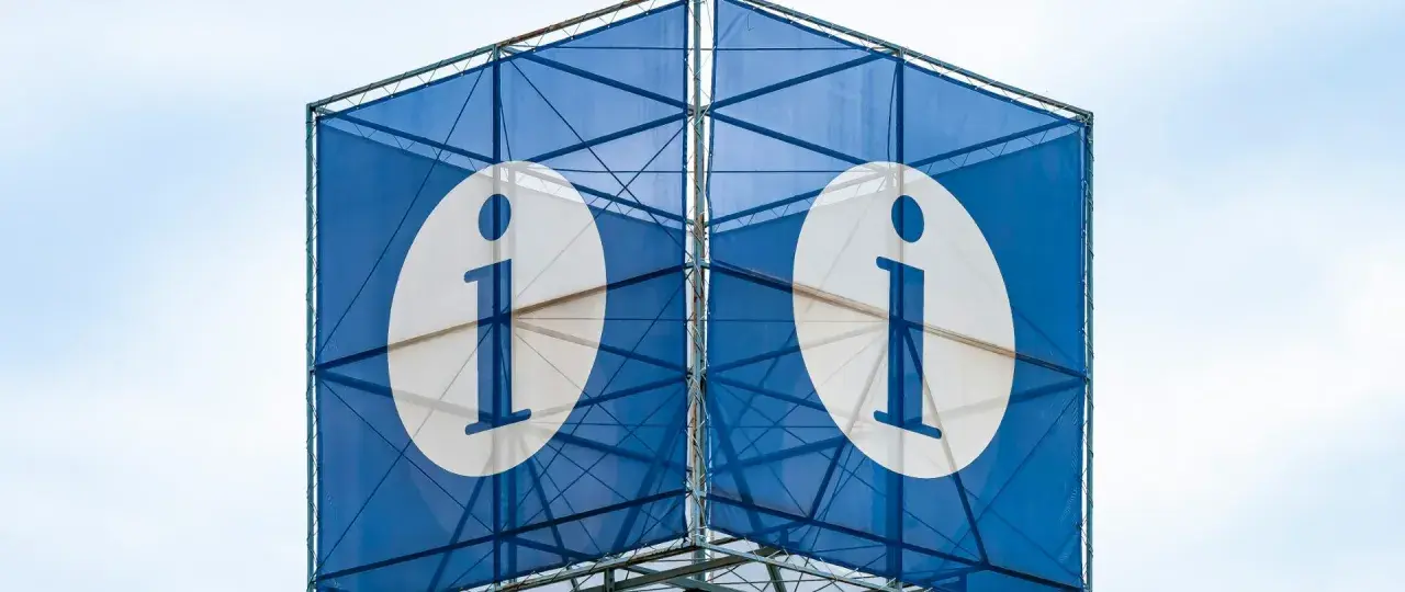 Niebieska konstrukcja z białymi okręgami i literą "i" symbolizuje system informacji.