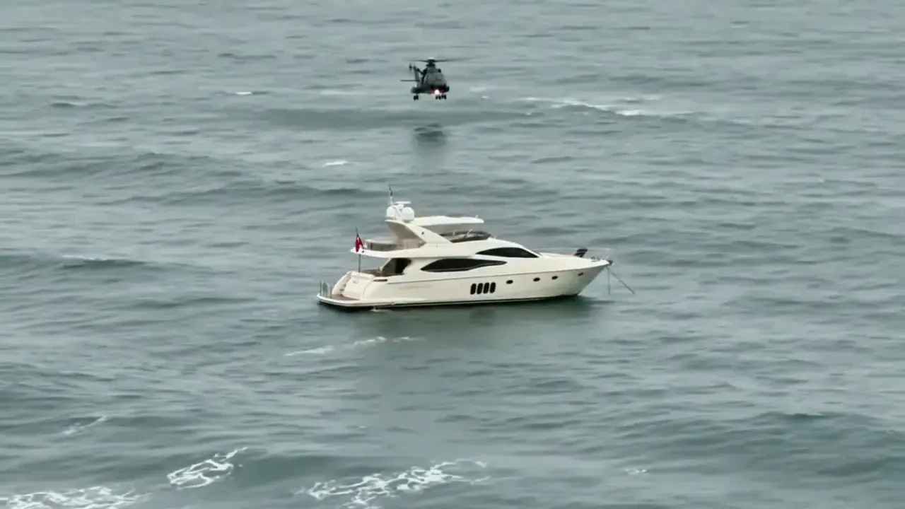 Luksusowy jacht motorowy na wzburzonym morzu, nad którym unosi się helikopter. Zastanawiasz się, ile pali jacht motorowy?